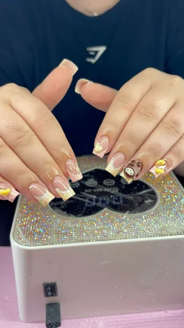 Square nails with pastel yellow and pink French tips, white lace detail, 3D banana charms and a 3D monkey design